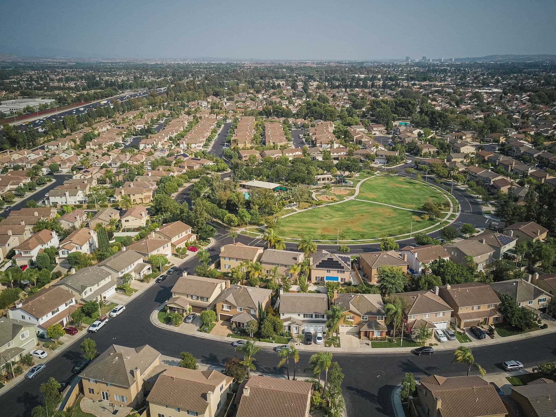 Aerial view of a suburban neighborhood with tree-lined streets and residential homes